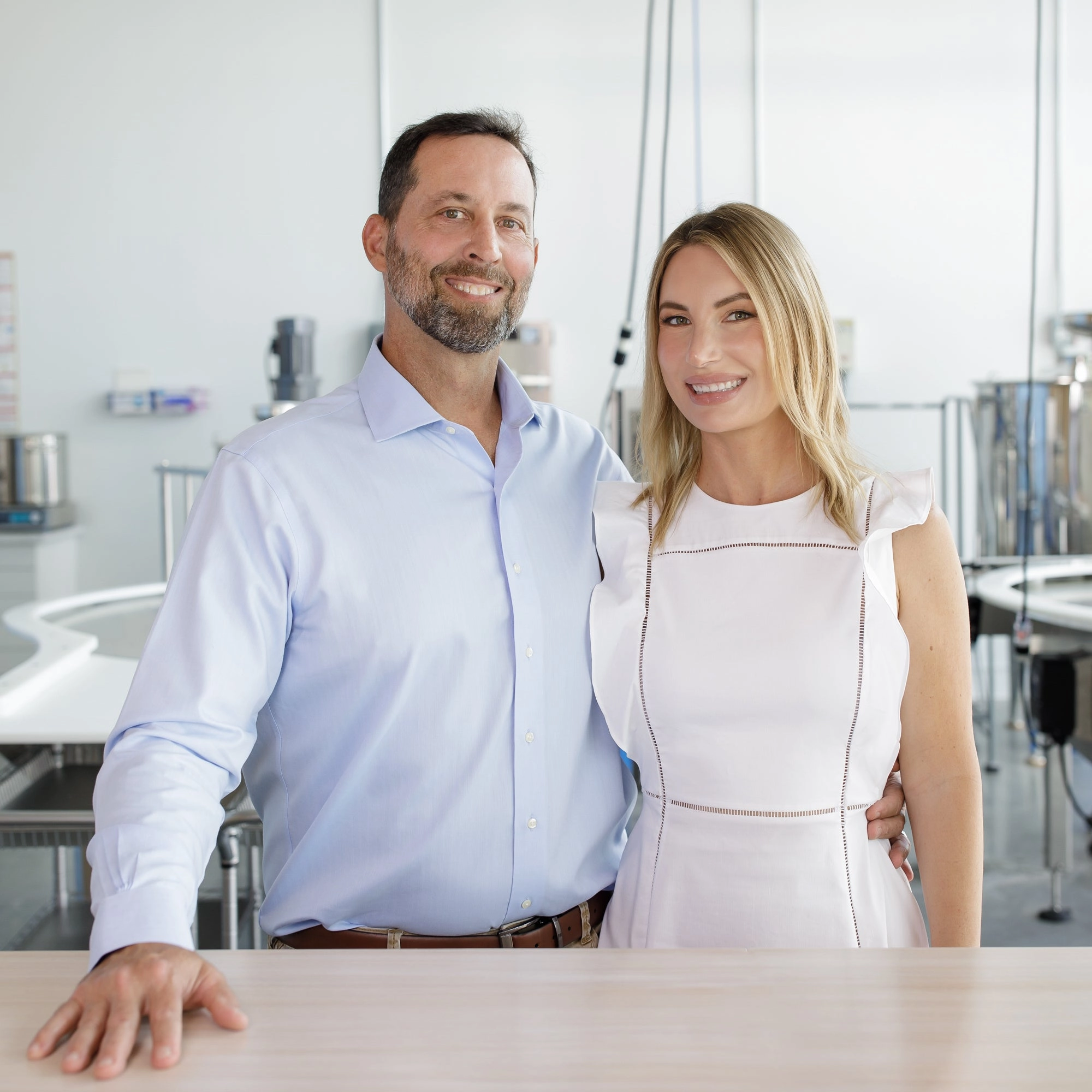Two people in white standing at a lab bench